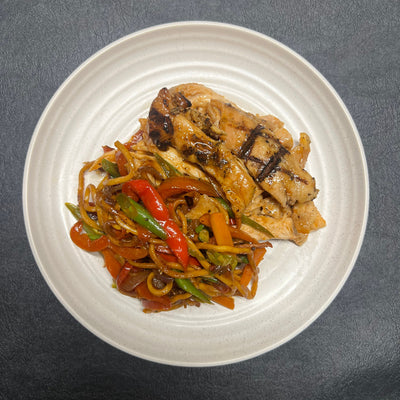 Plated dish of stir-fried vegetables and meat on a gray background